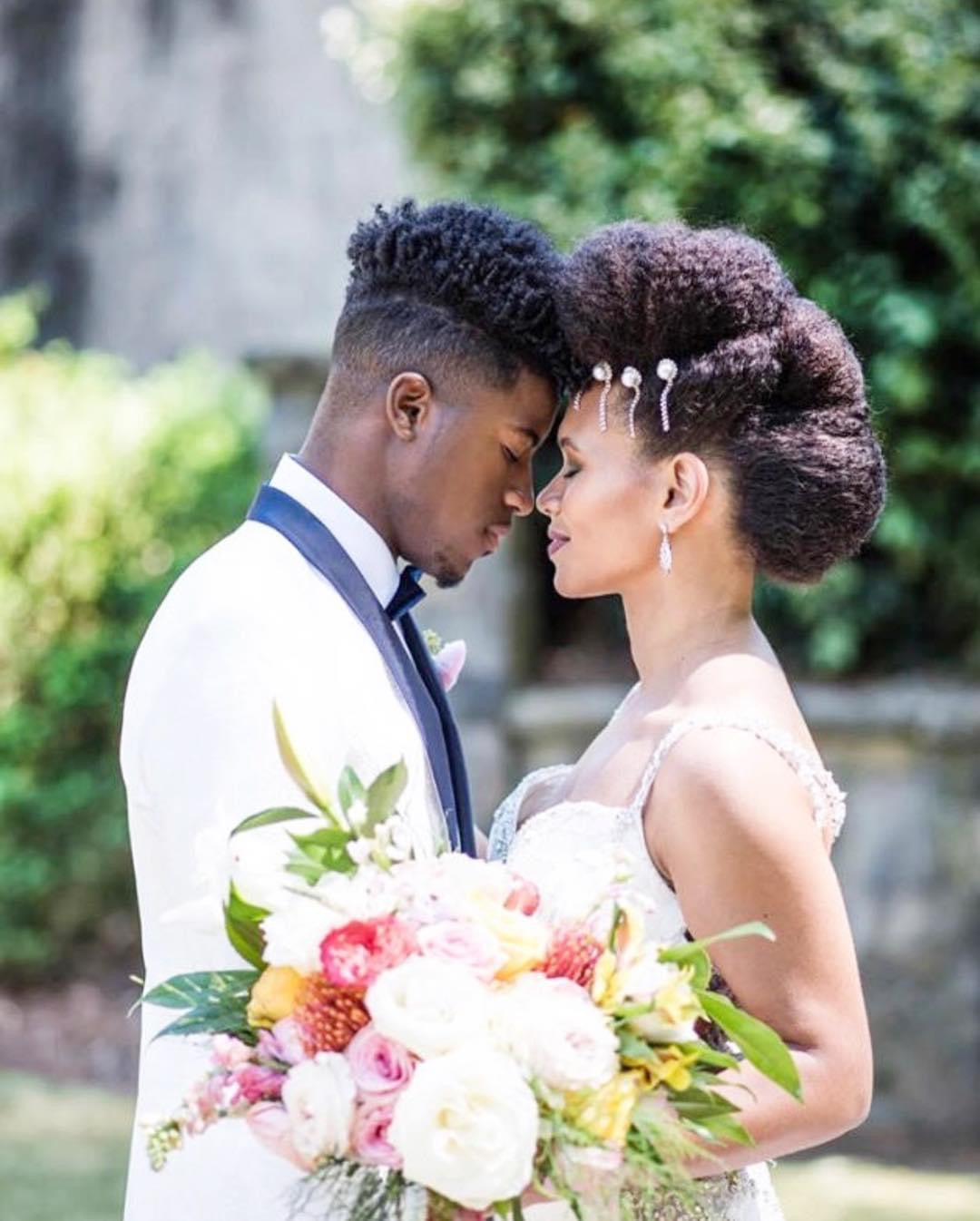 Intimate bridal couple forehead-to-forehead in garden setting