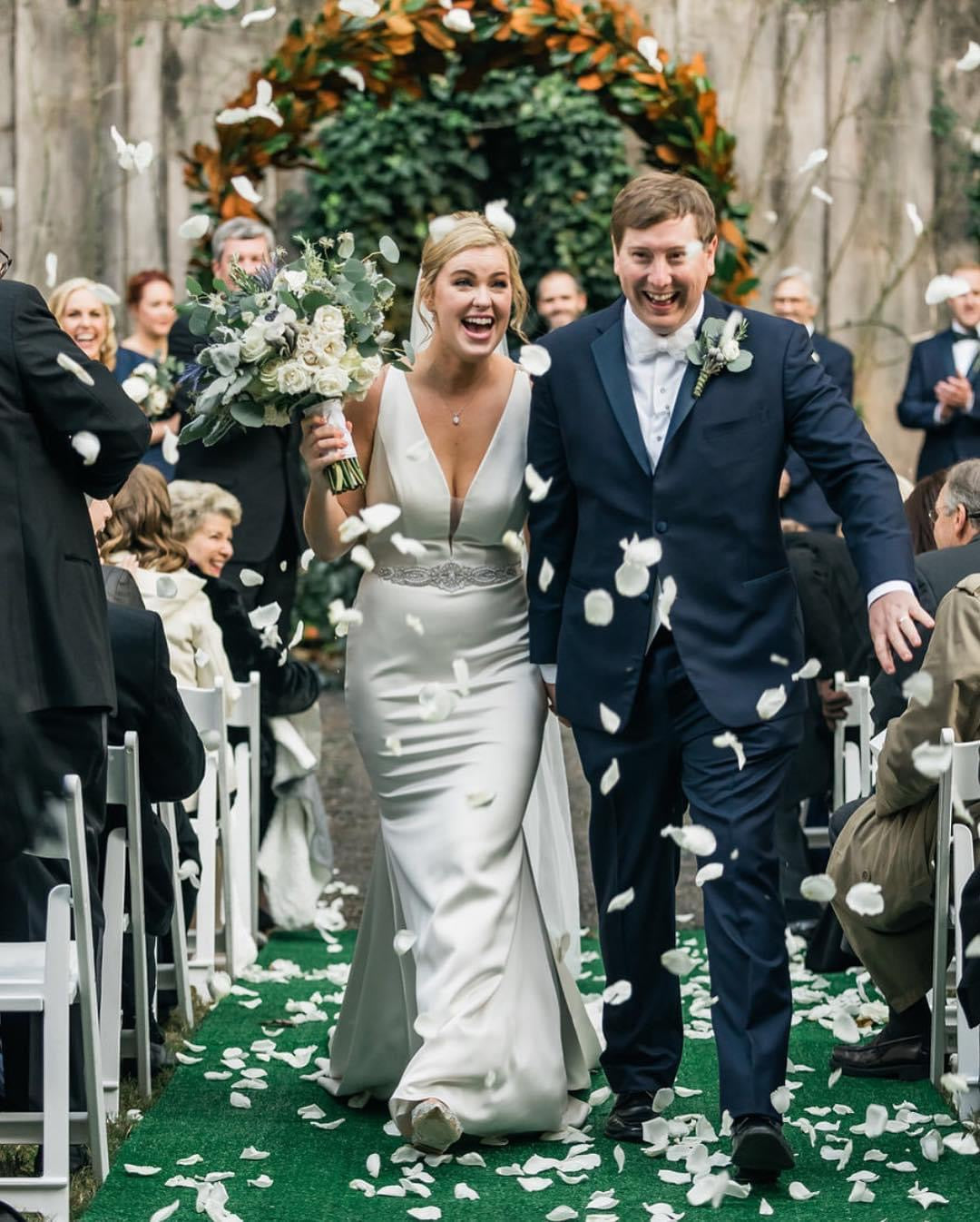 Joyful ceremony recessional with white rose petal toss