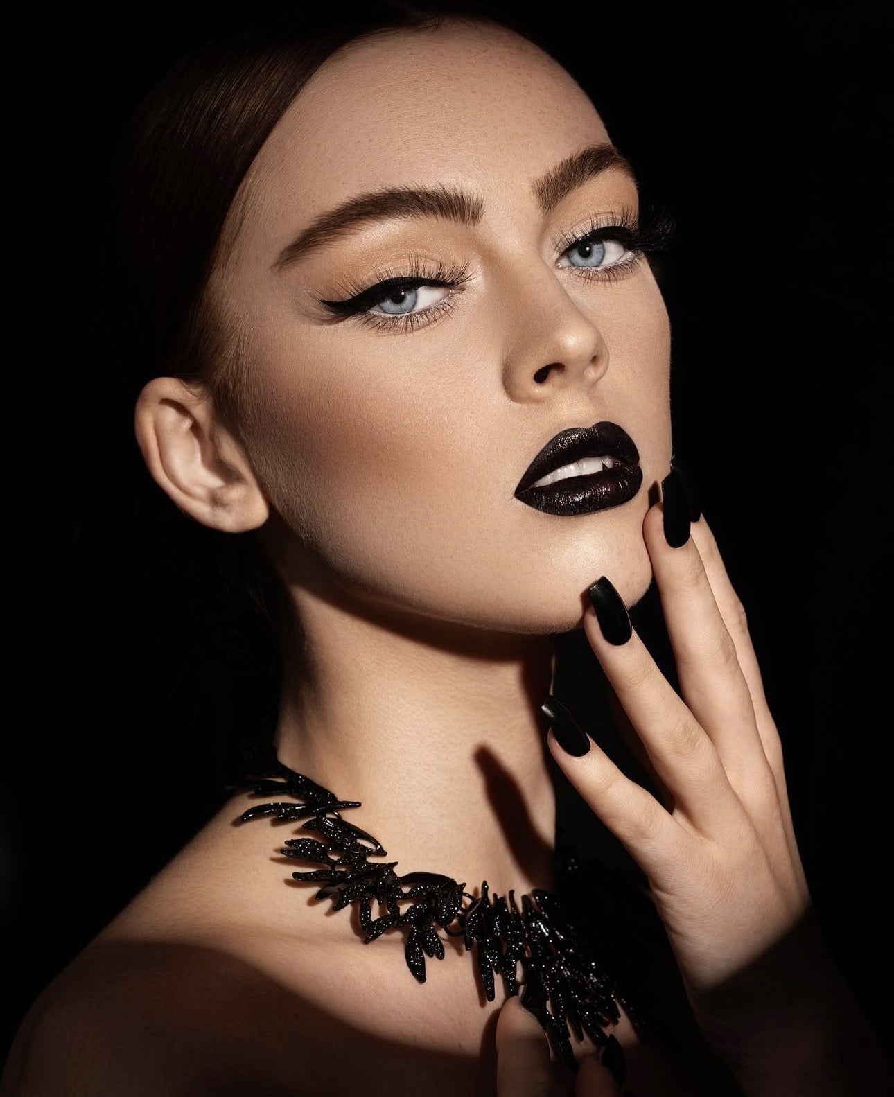 Dark glossy lip editorial with black statement necklace