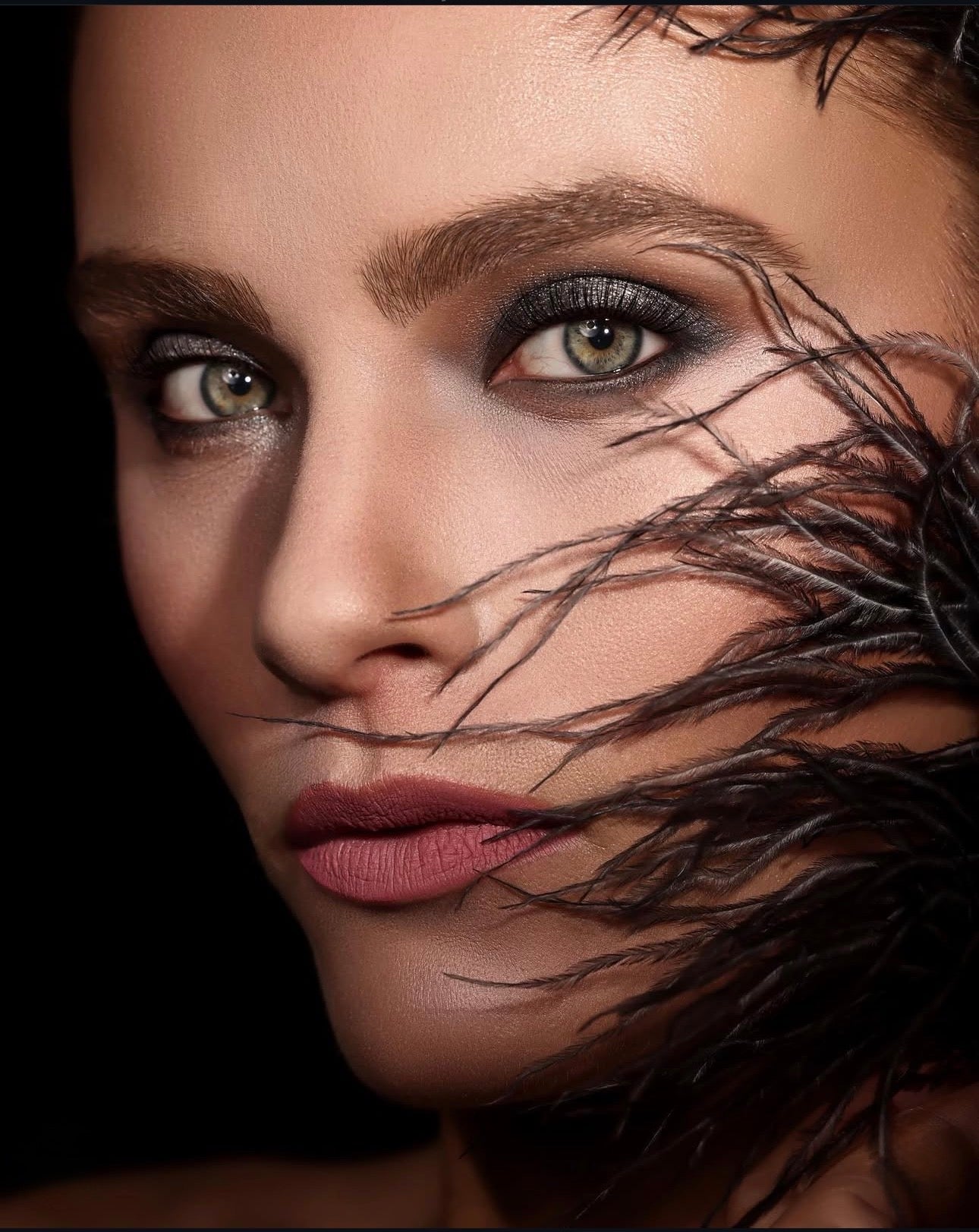 Conceptual beauty editorial with black feather accents